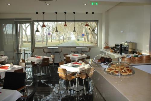 a restaurant with tables and a counter with food on it at Barquinha River House in Vila Nova da Barquinha