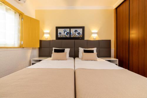 a bedroom with a large bed with two pillows at Rosa dos Ventos in Zambujeira do Mar