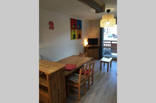 une cuisine avec une table en bois et une salle à manger dans l'établissement Appartement cosy Deux Alpes front de neige 34m2 6p, à Mont-de-Lans