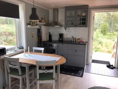 a kitchen with a table and a table and chairs at Joarsbo, Stuga 2, Gårdsstugan in Kalv