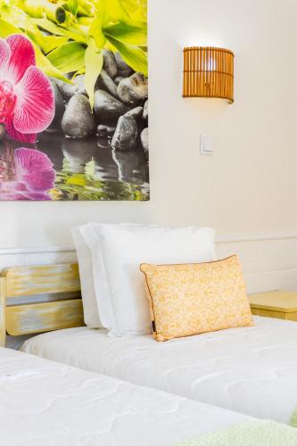 a bedroom with a bed with a painting on the wall at Rosa dos Ventos in Zambujeira do Mar