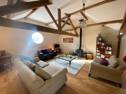 a living room with two couches and a table at Glanhenwye Courtyard Cottages in Glasbury
