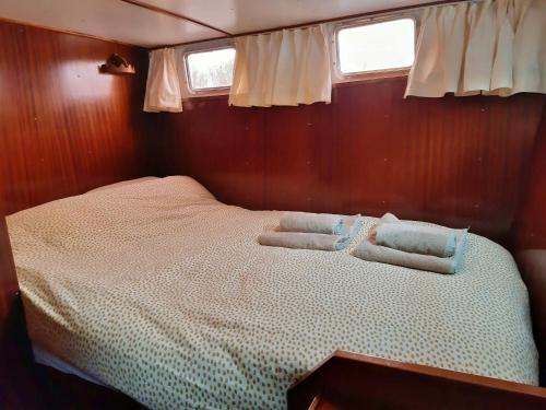 ein Bett auf der Rückseite eines Bootes in der Unterkunft Motor Yacht Almaz in Amsterdam