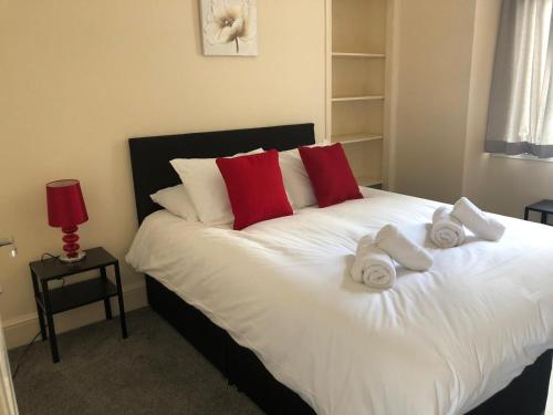a bedroom with a bed with towels on it at Comfy Stays Swansea in Swansea