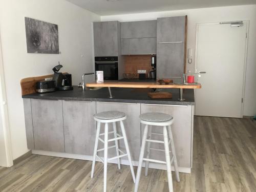 a kitchen with two bar stools at a counter at Schönblick in Pfronten