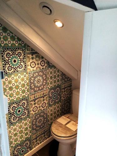 une salle de bain avec toilettes dans une petite pièce dans l'établissement Petit Studio Mansardé - 2 lits simples, à Neuilly