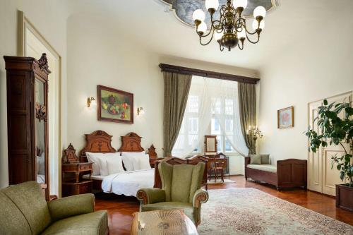 a living room filled with furniture and a large window at Grand Hotel Praha in Prague