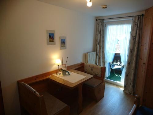 a living room with a table and a window at Gästehaus Sonnleit`n in Lenggries