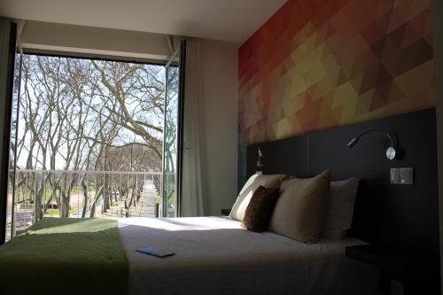 a bedroom with a bed and a large window at Barquinha River House in Vila Nova da Barquinha