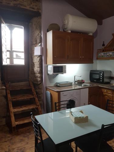 a kitchen with a table and a stove top oven at A Paragűeria in Sas de Penelas