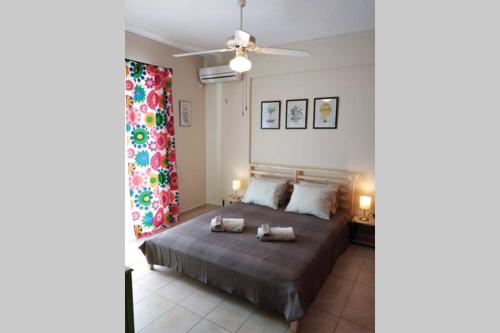 Schlafzimmer mit einem Bett und einem Deckenventilator in der Unterkunft Aloe apartment in Askeli in Poros