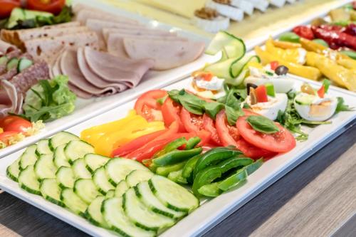 a buffet of different types of vegetables and meats at Hotel Demas City in Munich