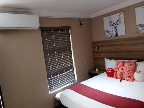 a bedroom with a bed and a window at The Hill Hotel and Conference Centre in Thohoyandou