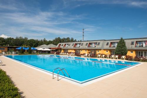 een groot zwembad voor een hotel bij Hotel Lacotel in Avenches