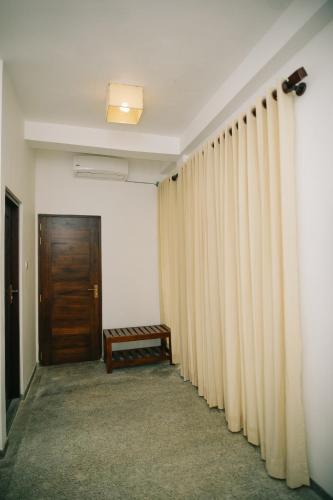 a hallway with curtains and a wooden door at Villa Lavish in Kandy