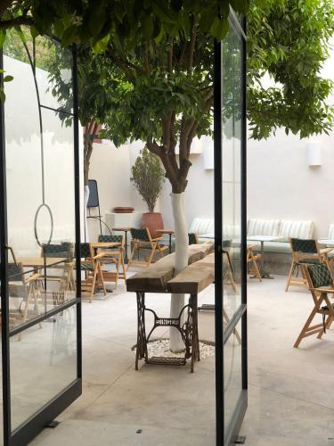 a table with a tree in a room with chairs at MORO Marrakech Boutique Hôtel in Marrakech