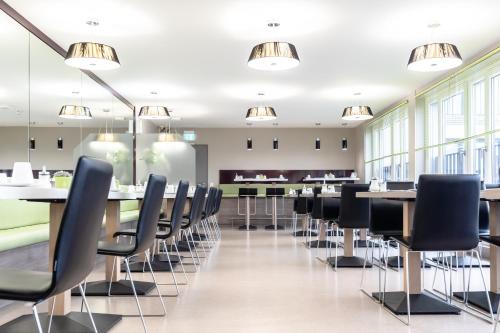 a conference room with tables and chairs at Hotel Demas City in Munich