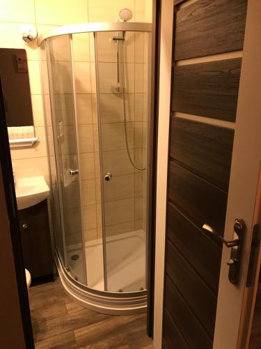 La salle de bains est pourvue d'une douche et d'une porte en verre. dans l'établissement Apartament przy starówce, à Gdańsk