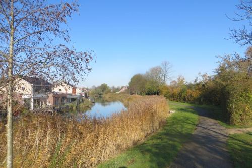 a river with a house on the side of it at B&B Biesehof in Kapelle