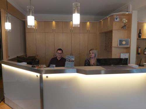 two people sitting at a counter in a restaurant at Hotel Montana Limburg in Limburg an der Lahn