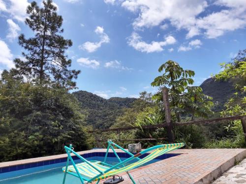 une paire de chaises assises à côté de la piscine dans l'établissement Sitio Sao Jeronimo, à Teresópolis