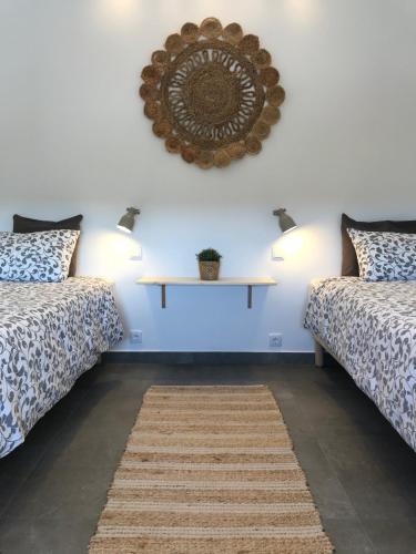 a room with two beds and a mirror on the wall at Bico das flores in Praia de Mira