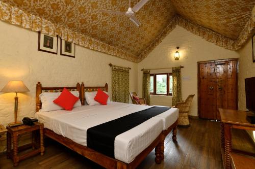 1 dormitorio con 1 cama grande con almohadas rojas en Hotel Sunbird, en Bharatpur
