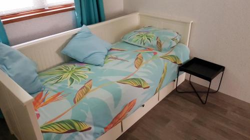 uma cama num quarto com uma cama com uma colcha com folhas em Modern en compleet chalet 22-15 em Putten