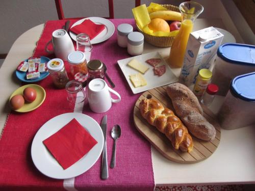 a table with breakfast food on a pink table cloth at BnB Cà di sciavatin in San Vittore