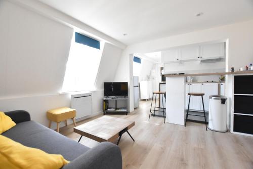 un salon avec un canapé et une cuisine dans l'établissement Appartement Dunkerque Centre, à Dunkerque