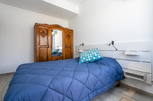 a bedroom with a blue bed and a mirror at Casa Mina in Faro