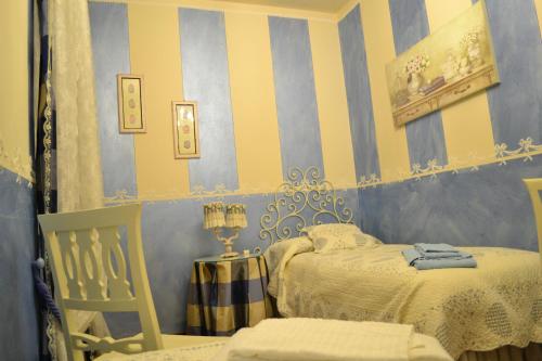 a bedroom with two beds and a chair in it at Relais De La Place in Desenzano del Garda
