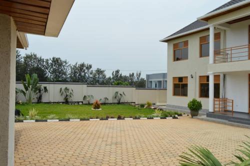a house with a patio and a yard at Isaro House Kigali in Kigali