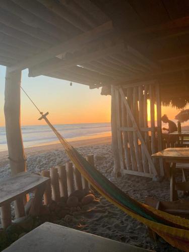 a hammock on the beach under a pavilion at Pelicano Surf Camp in La Libertad
