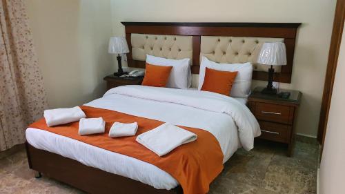 a bedroom with a large bed with two pillows on it at Sunset Hotel in Wadi Musa