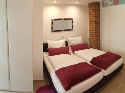 1 dormitorio con 1 cama grande con almohadas rojas en Haus Harzland en Wernigerode