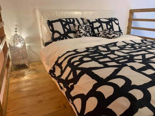 a bed with a black and white comforter in a room at Urban loft in Manciano