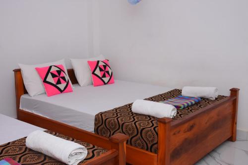 a bedroom with a bed with two pillows on it at Leesa Villa Safari Resort in Udawalawe