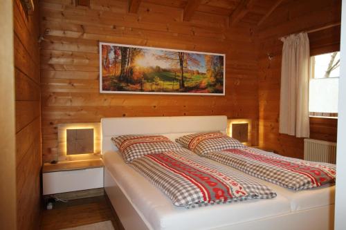 a bedroom with a bed in a wooden cabin at Romantikhütten 1 & 24 in Stamsried