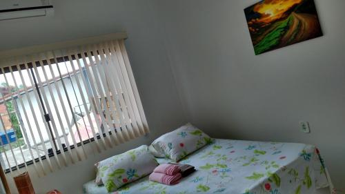 a bedroom with a bed with a pillow and a window at Pousada Recanto do Japa in Nilo Peçanha
