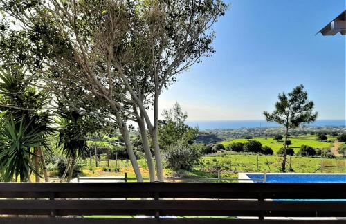a park bench with a view of the ocean at Villa Gavriel - Peyia Villa With Breathtaking Sea View, Peyia Villa With Private Pool, Secluded, Huge Outdoor Space, Mountain Views in Peyia
