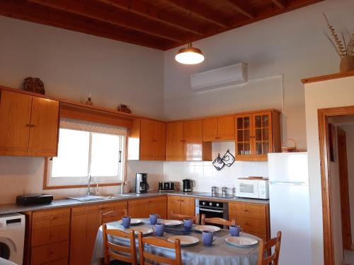 a kitchen with a table with blue cups on it at Villa Gavriel - Peyia Villa With Breathtaking Sea View, Peyia Villa With Private Pool, Secluded, Huge Outdoor Space, Mountain Views in Peyia