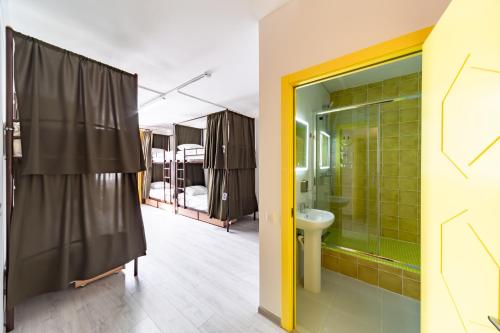 a bathroom with a shower with a sink and a mirror at Uley Hostel in Krasnogorsk