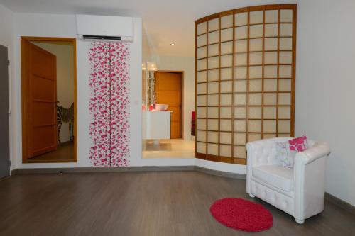 a living room with a white chair and a mirror at Les étangs du moulin d'Harcy in Lonny