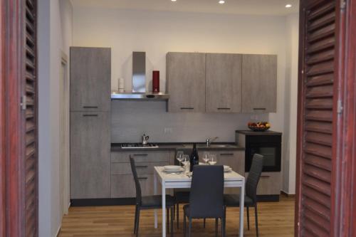 eine Küche mit einem weißen Tisch und Stühlen in einem Zimmer in der Unterkunft Appartamento del Golfo in Castellammare del Golfo