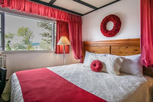Un dormitorio con una cama grande con una corona. en Gables Motel en Radium Hot Springs