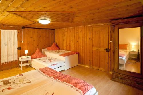 - une chambre avec 2 lits dans une pièce dotée de murs en bois dans l'établissement Wald-Ferienhaus-Seefried, à Immenstadt