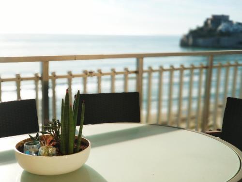 a white table with a plant on top of a balcony at Torre Hirta 1 in Peniscola