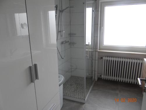 La salle de bains est pourvue d'une douche, de toilettes et d'une fenêtre. dans l'établissement Ferienwohnung Stein, à Verrenberg