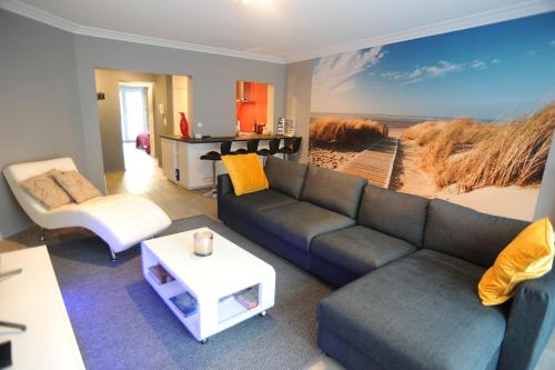 a living room with a couch and a painting of a beach at Knokke luxury appartement in Knokke-Heist